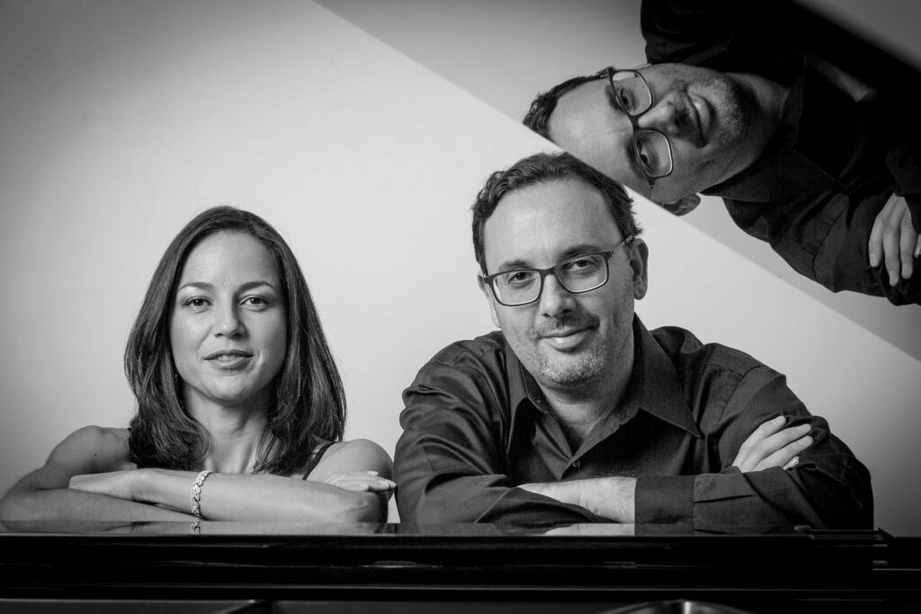 Nicolás Guerschberg y Marianela Villalobos sobre un piano en blanco y negro